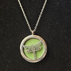 An aromatherapy essential oil diffuser locket necklace featuring a dragonfly